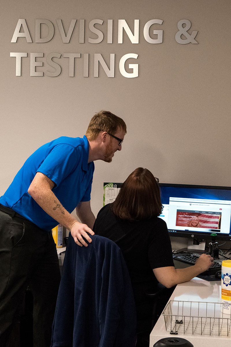 Ppsc advisor helping student at computer 